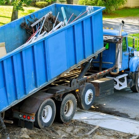 A large dumpster truck parked on the roadside.