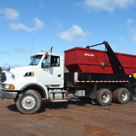 A red dumpster on the back of a dump truck. Dumpster Rentals in Bakersfield