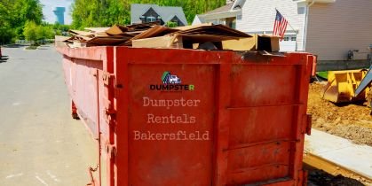 Construction dumpster on the roadside filled with debris and junk.