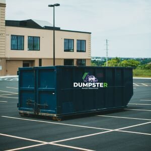 A dumpster positioned in a parking lot.