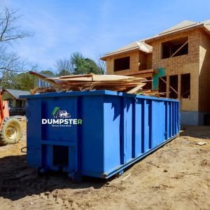 Commercial Dumpster Rentals - Bakersfield - CA A dumpster placed in front of a house that is currently under construction, surrounded by building materials and debris.